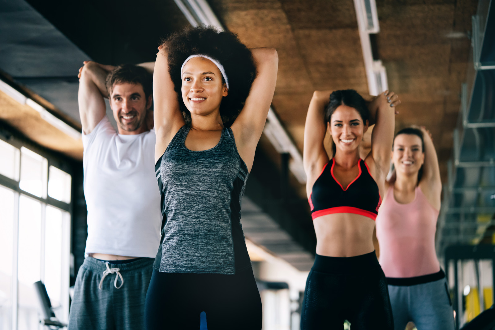 Group of fit young people at the gym exercising