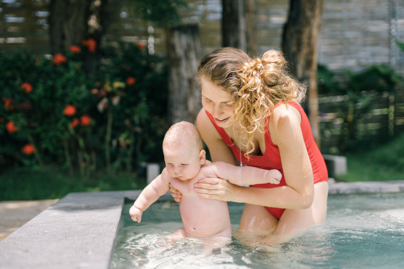 Woman in the pool with a baby